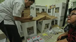 Petugas memasukkan logistik Pemilu 2019 ke kotak suara saat proses persiapan distribusi di Kecamatan Menteng, Jakarta, Senin (15/4). Proses pendistribusian ke tps masing-masing kelurahan diperkirakan akan tuntas sehari sebelum hari pencoblosan pada 17 April 2019. (Liputan6.com/Faizal Fanani)