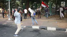 Pelajar melempari Gedung DPR dengan batu saat berunjuk rasa di Palmerah, Jakarta, Rabu (25/9/2019). Pihak kepolisian menembakan gas air mata untuk memukul mundur pelajar. (Liputan6.com/Angga Yuniar)
