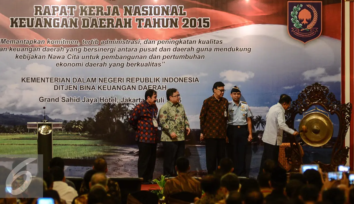 Wapres Jusuf Kalla (kanan) memukul gong sebagai tanda dibukanya Rapat Kerja Nasional Keuangan Daerah Tahun 2015 di Jakarta, Kamis (2/7/2015). Menurut JK, krisis Yunani bisa dijadikan pelajaran agar tak terjadi di Indonesia. (Liputan6.com/Faizal Fanani)
