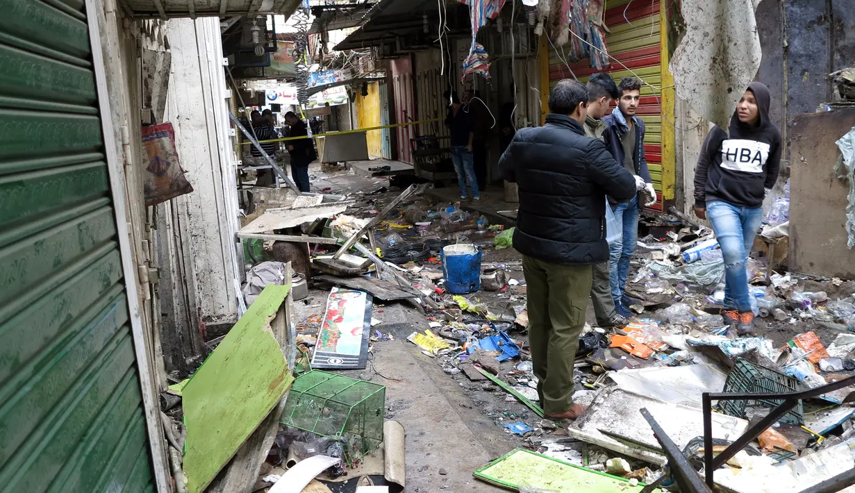 Petugas keamanan Irak memeriksa lokasi serangan bom yang terjadi di sebuah pasar di Baghdad, Irak (31/12). Pusat ledakan bom terjadi di dekat toko yang menjual suku cadang mobil di pasar al-Sinak. (Reuters/Ali al-Mashhadan )