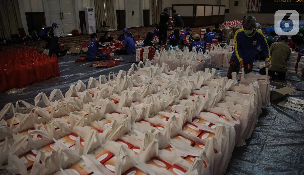 Petugas Taruna Siaga Bencana menyiapkan nasi kotak di Dapur Umum Kementerian Sosial Peduli Dampak Covid-19 di Kompleks Gedung Konvensi TMP Nasional-Utama, Kalibata, Jakarta, Rabu (8/4/2020). Paket nasi itu didistribusikan ke warga DKI yang terdampak pandemi Covid-19. (Liputan6.com/Faizal Fanani)