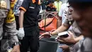 Petugas kepolisian membawa keluar jenazah pembunuhan di Jalan Pulomas Utara Nomor 7A, Kayuputih, Pulogadung, Jakarta, Selasa (27/12). Polisi tidak menemukan barang berharga yang hilang dalam peristiwa tersebut. (Liputan6.com/Faizal Fanani)