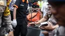 Petugas kepolisian membawa keluar jenazah pembunuhan di Jalan Pulomas Utara Nomor 7A, Kayuputih, Pulogadung, Jakarta, Selasa (27/12). Polisi tidak menemukan barang berharga yang hilang dalam peristiwa tersebut. (Liputan6.com/Faizal Fanani)