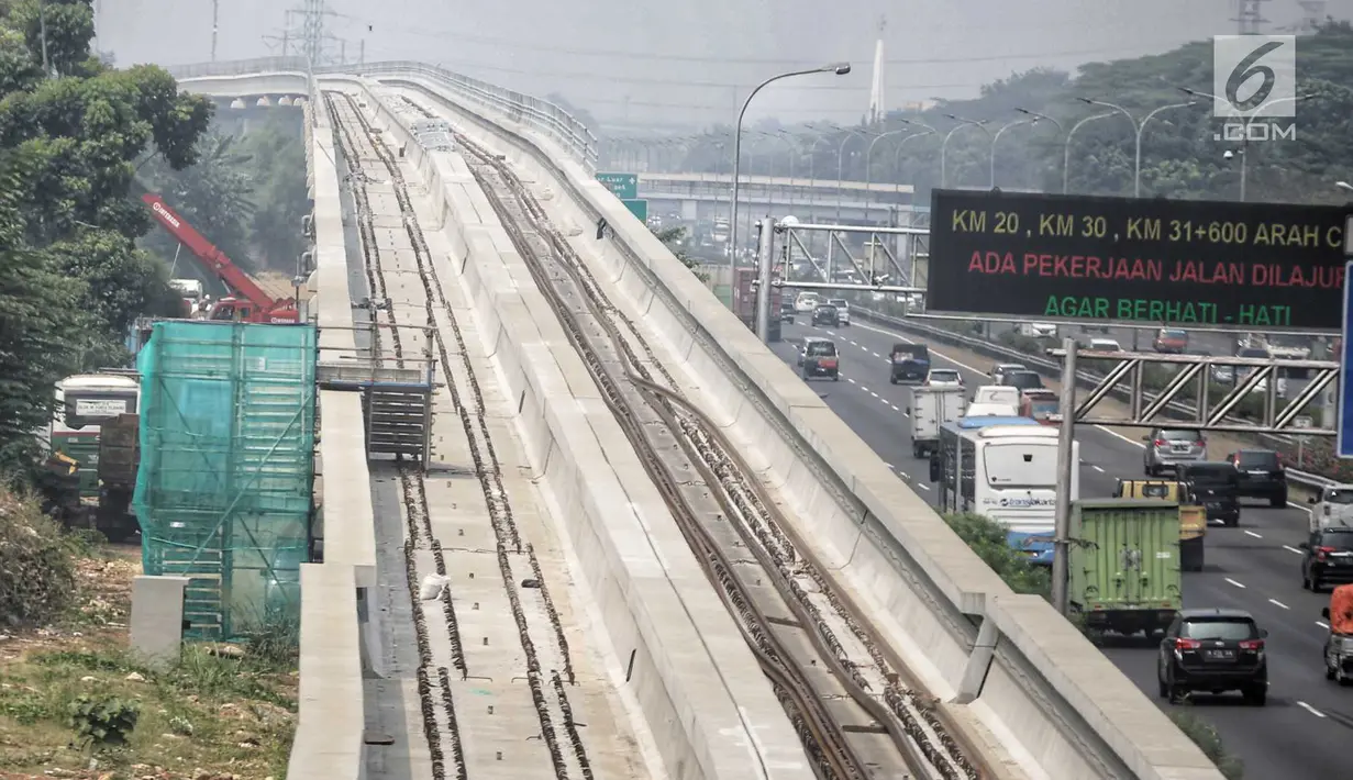 Sejumlah kendaraan melintas dekat pembangunan proyek kereta api ringan atau LRT di kawasan Kampung Makasar, Jakarta, Kamis (26/7). Proyek LRT Jakarta diusahakan selesai sesuai target, yakni seminggu sebelum Asian Games 2018. (Liputan6.com/Faizal Fanani)