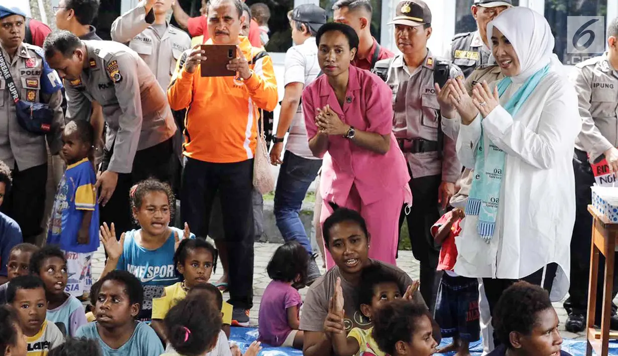 Ketum Bhayangkari, Tri Suswati Tito Karnavian bersama Polwan melakukan trauma healing dengan mengajak bernyanyi dan bermain bersama anak-anak  korban bencana banjir Sentani di Kabupaten Jayapura, Papua, Jumat (22/3).(Liputan6.com/Pool/Humas Mabes Polri)