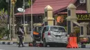 Petugas kepolisian mengamankan mobil yang digunakan terduga teroris setelah serangan di luar markas polisi di Pekanbaru, Riau (16/5). Empat pelaku penyerangan ditembak dan tewas ketika mereka melakukan serangan.  (AFP Photo/Dedy Sutisna)