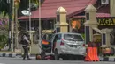 Petugas kepolisian mengamankan mobil yang digunakan terduga teroris setelah serangan di luar markas polisi di Pekanbaru, Riau (16/5). Empat pelaku penyerangan ditembak dan tewas ketika mereka melakukan serangan.  (AFP Photo/Dedy Sutisna)