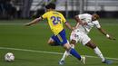 Pemain Real Madrid Rodrygo (kanan) memperebutkan bola dengan pemain Cadiz Jairo Izquierdo pada pertandingan La Liga Spanyol di Stadion Ramon Carranza, Cadiz, Spanyol, Rabu (21/4/2021). Real Madrid menang 3-0. (AP Photo/Jose Breton)