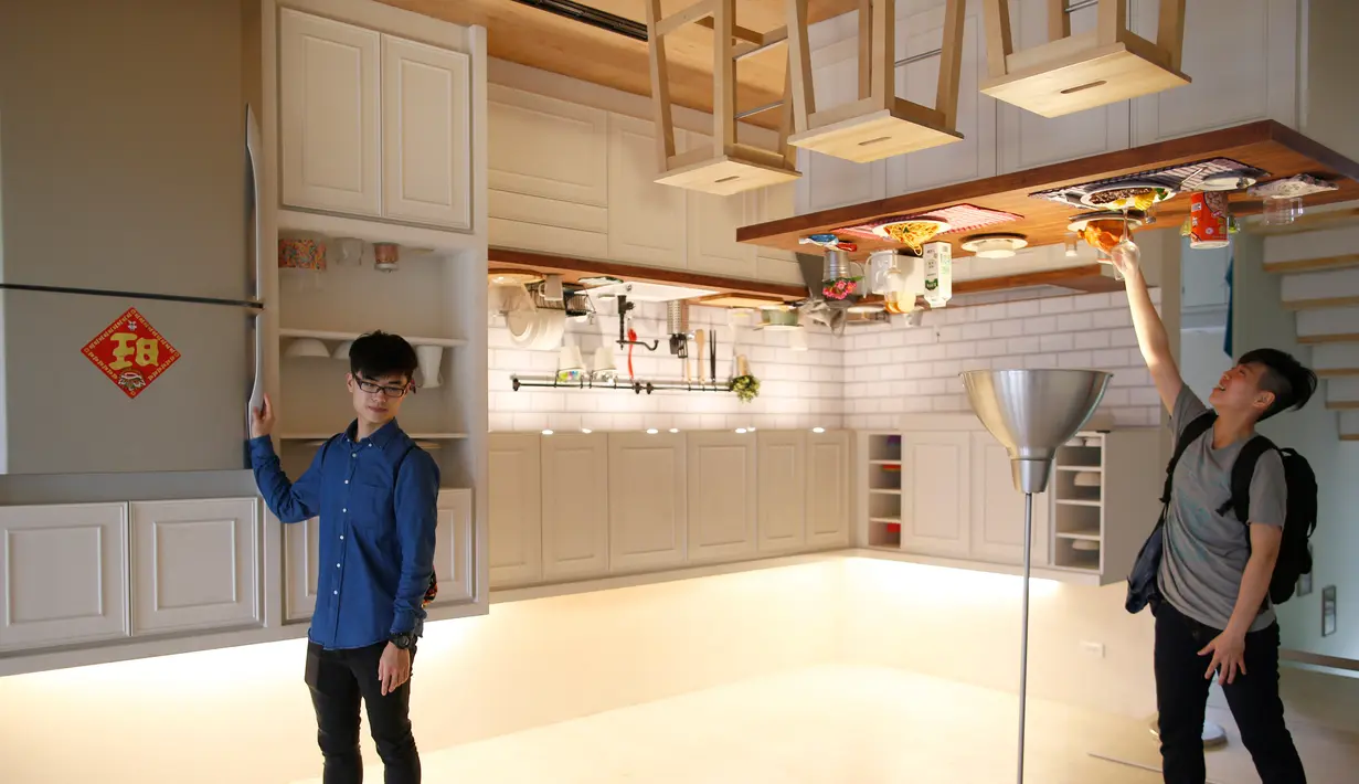 Pengunjung berpose di ruangan dapur rumah terbalik di Huashan Creative Park, Taipei, Taiwan, (7/4). Sekelompok arsitek Taiwan membangun rumah seluas 300 meter yang menghabiskan dana US$ 600.000 dalam kurun waktu 2 bulan. (REUTERS/Tyrone Siu)