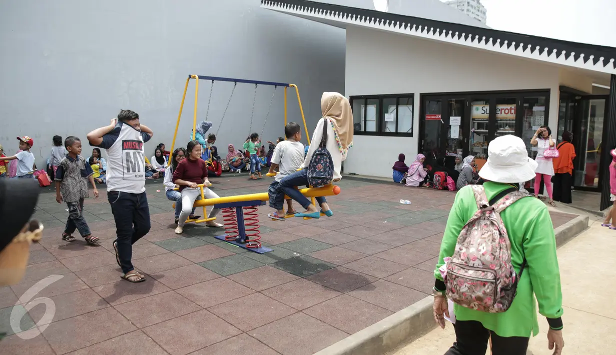 Sejumlah warga menghabiskan waktu di areal RPTRA Kalijodo, Jakarta, Jumat (14/4). Sejumlah warga menghabiskan libur Paskah dengan mengajak putra-putrinya bermain di areal RPTRA Kalijodo. (Liputan6.com/Faizal Fanani)