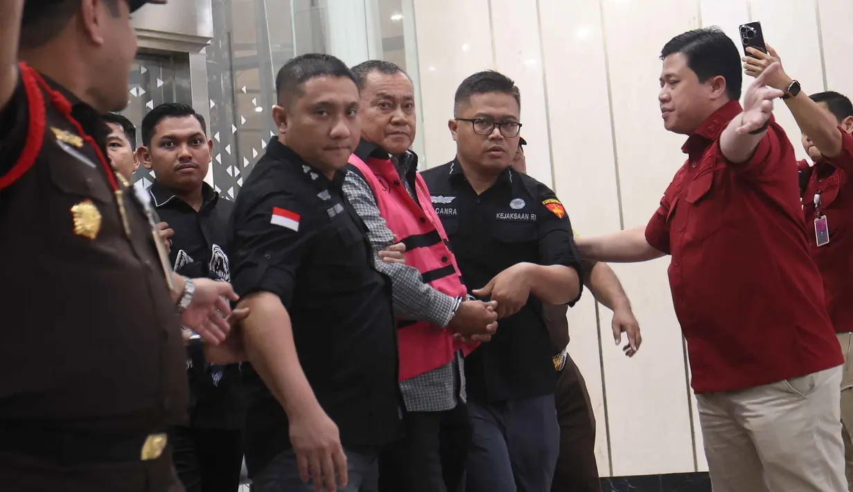 Mantan Wakil Kepala Badan Gizi Nasional (BGN), Lodewyk Pusung (mengenakan rompi tahanan), digiring menuju mobil tahanan usai menjalani pemeriksaan di Gedung Kejaksaan Agung RI, Jakarta, Rabu (3/6/2026). (Kapanlagi.com/Budy Santoso)