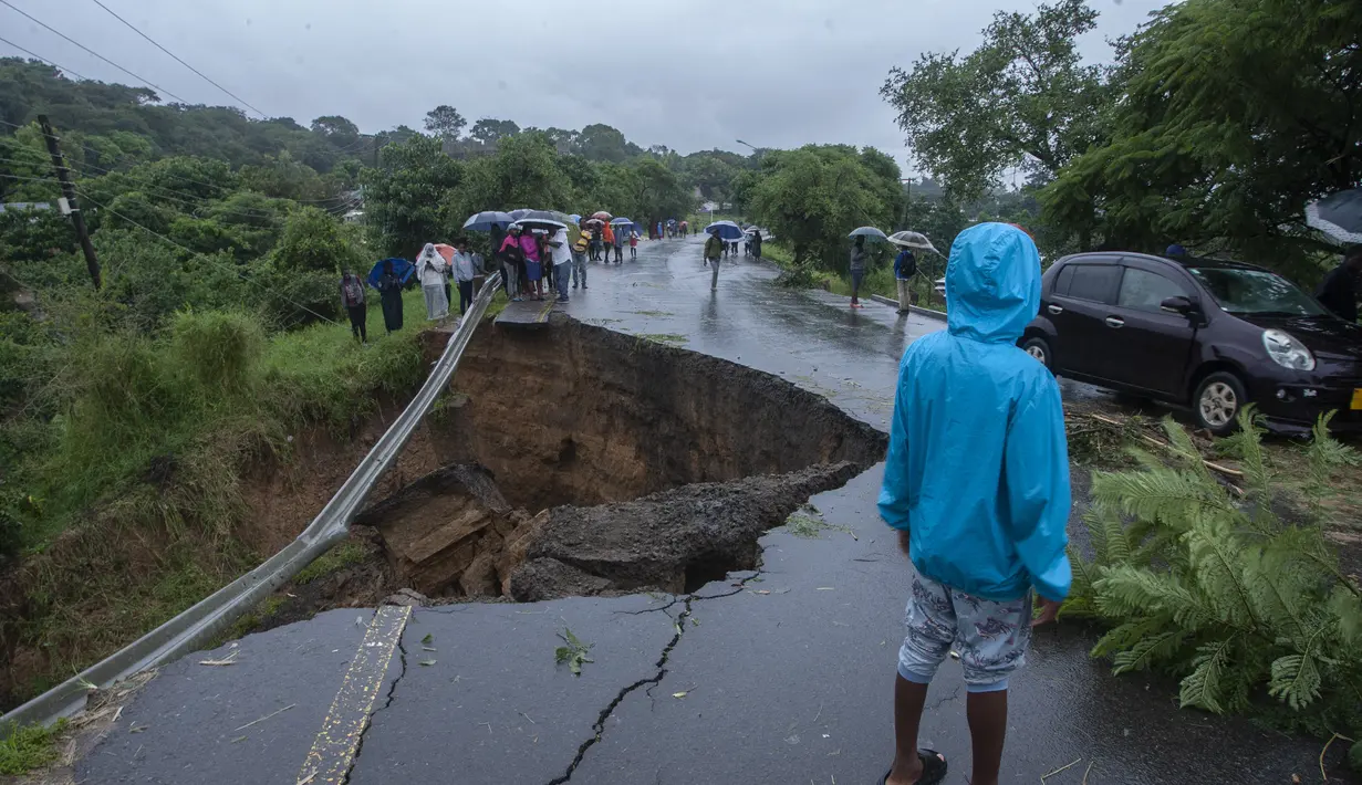 Jalan yang runtuh akibat banjir akibat hujan lebat menyusul topan Freddy di Blantyre, Malawi, pada 13 Maret 2013. Pemimpin Malawi pada 13 Maret 2023 mengumumkan keadaan bencana di beberapa distrik selatan termasuk komersial hub Blantyre setelah topan kuat Freddy kembali menawaskan ratusan orang. (AFP/Amos Gumulira)