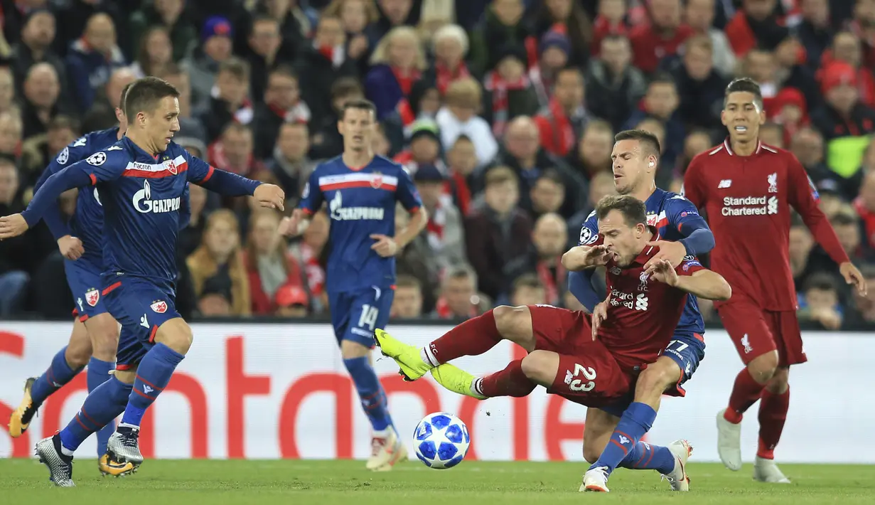 Gelandang Liverpool, Xherdan Shaqiri, terjatuh saat berebut bola dengan pemain Crvena Zvezda, Marko Marin, pada laga Liga Champions, di Stadion Anfield, Rabu (24/10/2018). Liverpool menang 4-0 atas Crvena Zvezda. (AP/Jon Super)