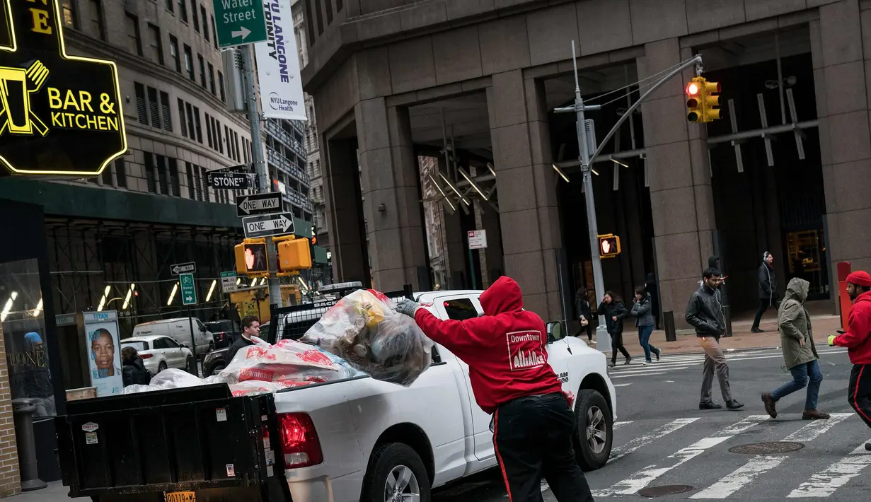 Pekerja mamasukan sampah ke truk di Lower Manhattan di New York City (22/2). Dengan menggunakan data dari Environmental Protection Agency memberi peringkat New York City sebagai kota paling kotor di negara tersebut. (AFP Photo/Drew Angerer)