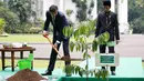 Presiden Joko Widodo (kanan) saat menemani Emir Qatar Syekh Tamim bin Hamad Al Thani menanam pohon eboni di Istana Bogor, Jawa Barat, Rabu (18/10). Pohon eboni merupakan pohon endemik atau kayu hitam Sulawesi. (Beawiharta/Pool photo via AP)