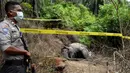 Aparat bersenjata mengamankan lokasi penemuan gajah betina yang mati karena keracunan di Desa Semanah Jaya, Aceh Timur, Kamis (21/11/2019). Bangkai gajah betina berusia 25 tahun itu ditemukan di sebuah perkebunan kelapa sawit pada hari ini. (CEK MAD/AFP)