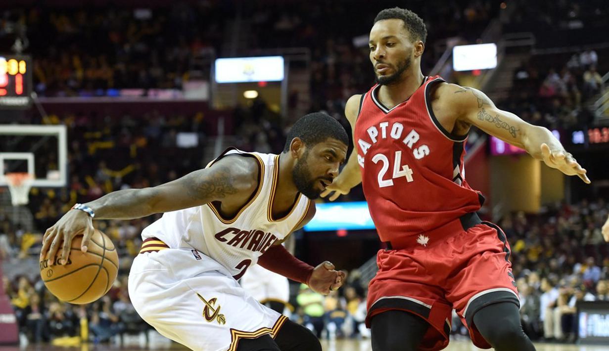 Pemain Cleveland Cavaliers, Kyrie Irving (kiri), berusaha melewati pemain Toronto Raptors, Norman Powell, pada laga pramusim NBA di Quicken Loans Arena, Jumat (14/10/2016). (Reuters/David Richard-USA TODAY Sports)