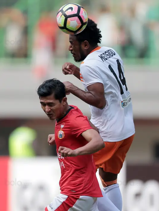 Duel pemain Persija Jakarta, Rudi Widodo (kiri) dan pemain Perseru Serui, Ronaldo Meosido pada lanjutan Liga 1 2017 di Stadion Patriot Bekasi, Selasa (19/9/2017). Persija menang 1-0. (Bola.com/Nicklas Hanoatubun)