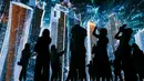 Pengunjung mengambil gambar saat pertunjukan cahaya dalam pameran untuk mempromosikan Piala Dunia 2022 di museum multimedia Qatar Elements, Gorky Park, Moskow, Rusia, Kamis (12/7). (Maxim ZMEYEV/AFP)