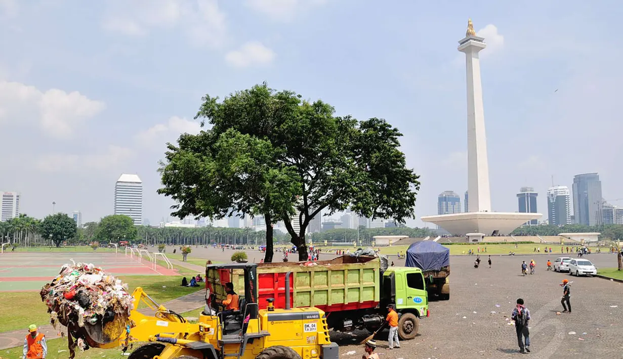 Beberapa truk dikerahkan untuk mengangkuti sampah yang mulai menggunung di kawasan Monumen Nasional, Jakarta, (31/7/2014). (Liputan6.com/Faizal Fanani)