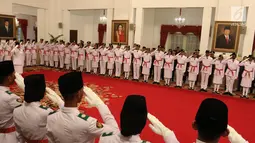 Anggota Pasukan Pengibar Bendera Pusaka (Paskibraka) memberi hormat kepada Presiden Joko Widodo saat dikukuhkan di Istana Negara, Jakarta, Kamis (15/8/2019). Sebanyak 68 anggota Paskibraka tersebut akan bertugas pada upacara HUT ke-74 RI. (Liputan6.com/Angga Yuniar)