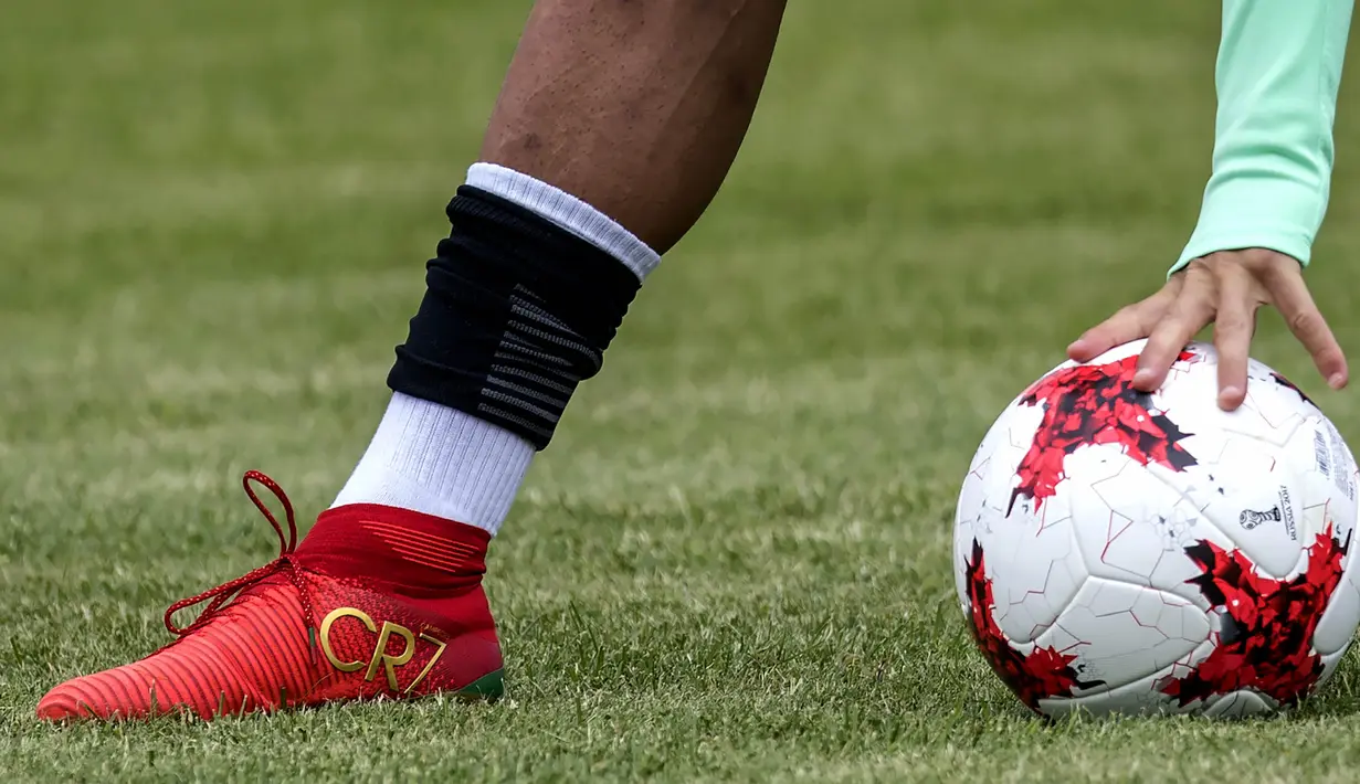 Bintang Portugal, Cristiano Ronaldo, memakai sepatu dengan inisial namanya saat latihan jelang laga penyisihan grup Piala Konfederasi di St Petersburg, Rusia, Jumat (23/6/2017). (EPA/Georgi Licovski)