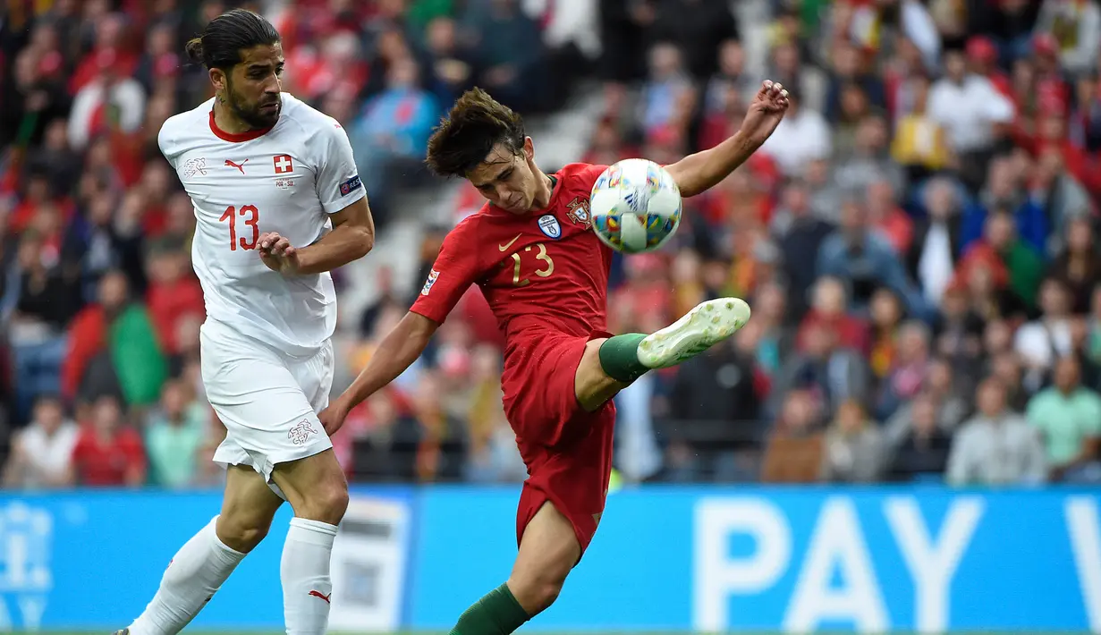 Gelandang Portugal Joao Felix (kanan) berusaha menendang bola dari kawalan bek Swiss, Ricardo Rodriguez saat pertandingan semifinal Liga Bangsa-Bangsa UEFA di stadion Dragao di Porto pada 5 Juni 2019. (AFP Photo/Miguel Riopa)