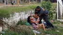Kerabat narapidana bentrok dengan polisi di luar penjara Tacumbu  setelah kerusuhan, Asuncion, Paraguay, Selasa (16/2/2021). Sebanyak 100 narapidana di penjara terbesar di Paraguay ini merebut kekuasaan di sayap dan menyandera 18 penjaga. (AP Photo/Jorge Saenz)