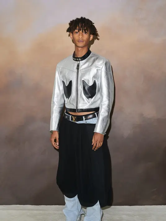 Jaden Smith tampil edgy dengan atasan silver dengan dua kantong hitam di sisi kanan-kiri. Bawahan hitam yang unik, ia padukan dengan sneakers putih. Foto: Document/Louis Vuitton.