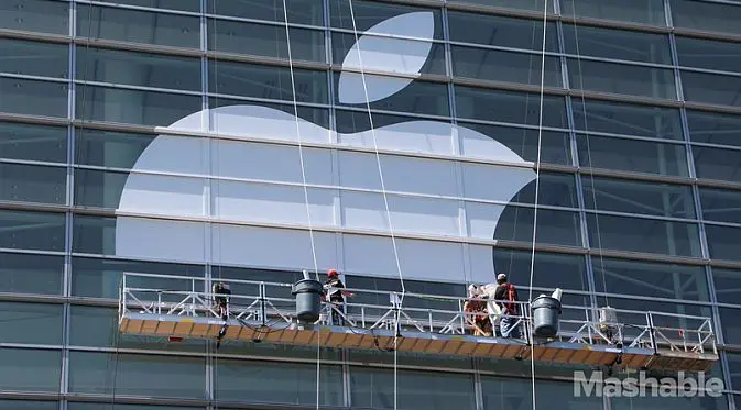 Para pekerja tengah memasang logo Apple di Moscone West pada 3 Juni (Foto: Mashable)