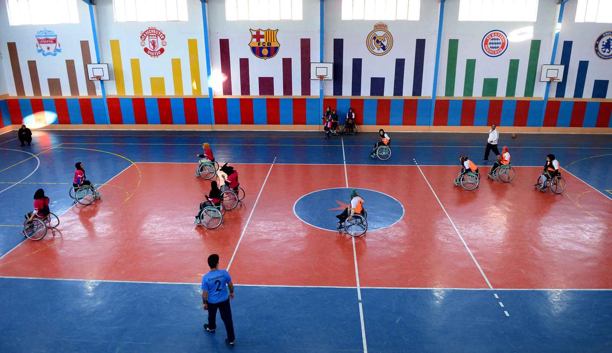  Tim Kahkashan (orange) dan tim Sitara (merah) beraksi pada Turnamen Basket Kursi Roda untuk penyandang cacat di Provinsi Herat, Afghanistan, Minggu (29/11/2015). (AFP Photo/Aref Karimi).