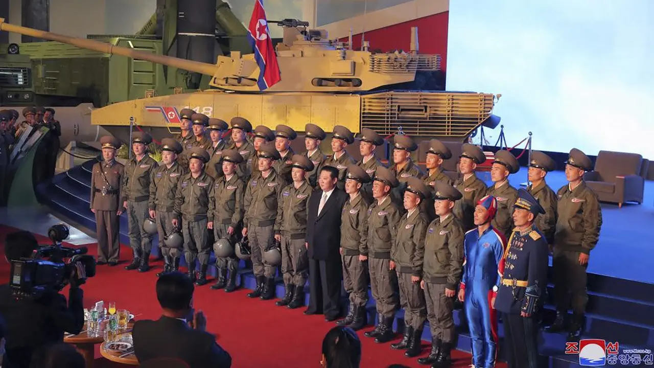 Pemimpin Korea Utara Kim Jong-un (tengah) berpose untuk foto bersama dengan pilot pesawat tempur yang melakukan penerbangan demonstrasi pada pembukaan pameran sistem senjata di Pyongyang, Korea Utara, Senin, Okt .11, 2021. (KCNA/AP)