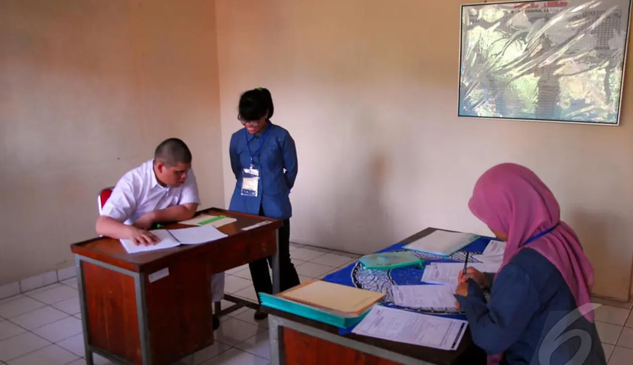 Dua orang pengawas membantu pelaksanaan Ujian Nasional untuk siswa berkebutuhan khusus di Lebak Bulus, Jakarta, Senin (5/5/2014) (Liputan6.com/Miftahul Hayat).  