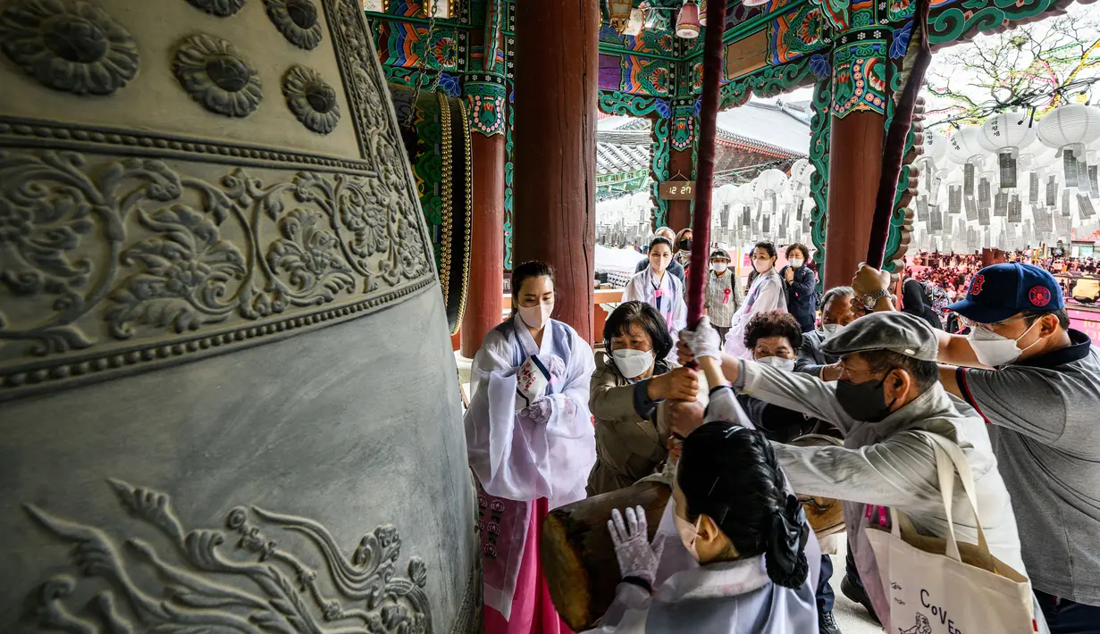 <p>Para jemaah membunyikan lonceng besar setelah kebaktian untuk merayakan ulang tahun Buddha di Kuil Jogye, Seoul, Korea Selatan, Minggu (8/5/2022). (ANTHONY WALLACE/AFP)</p>