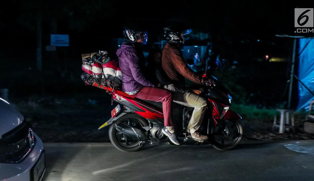 Pemudik bermotor membawa barang bawaannya melintas di jalur pantura kawasan Indramayu, Jawa Barat, Minggu (2/7). Lebaran H+7, arus balik pemudik yang mengendarai sepeda motor mulai terlihat memadati jalur pantura. (Liputan6.com/Faizal Fanani)