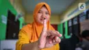 Warga menunjukkan tanda tinta usai melakukan pencoblosan surat suara pada pemilu 2024 susulan di wilayah Kelurahan Larangan Utara, Kecamatan Larangan, Kota Tangerang, Banten, Minggu (18/2/2024). (Liputan6.com/Angga Yuniar)