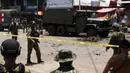Tubuh korban (tengah) tergeletak saat polisi dan tentara mengamankan lokasi ledakan di Kota Jolo, Pulau Sulu, Filipina, Senin (24/8/2020). Sebanyak 10 orang tewas dan puluhan lainnya terluka -banyak dari mereka tentara atau polisi- dalam pemboman ganda tersebut. (Nickee BUTLANGAN/AFP)