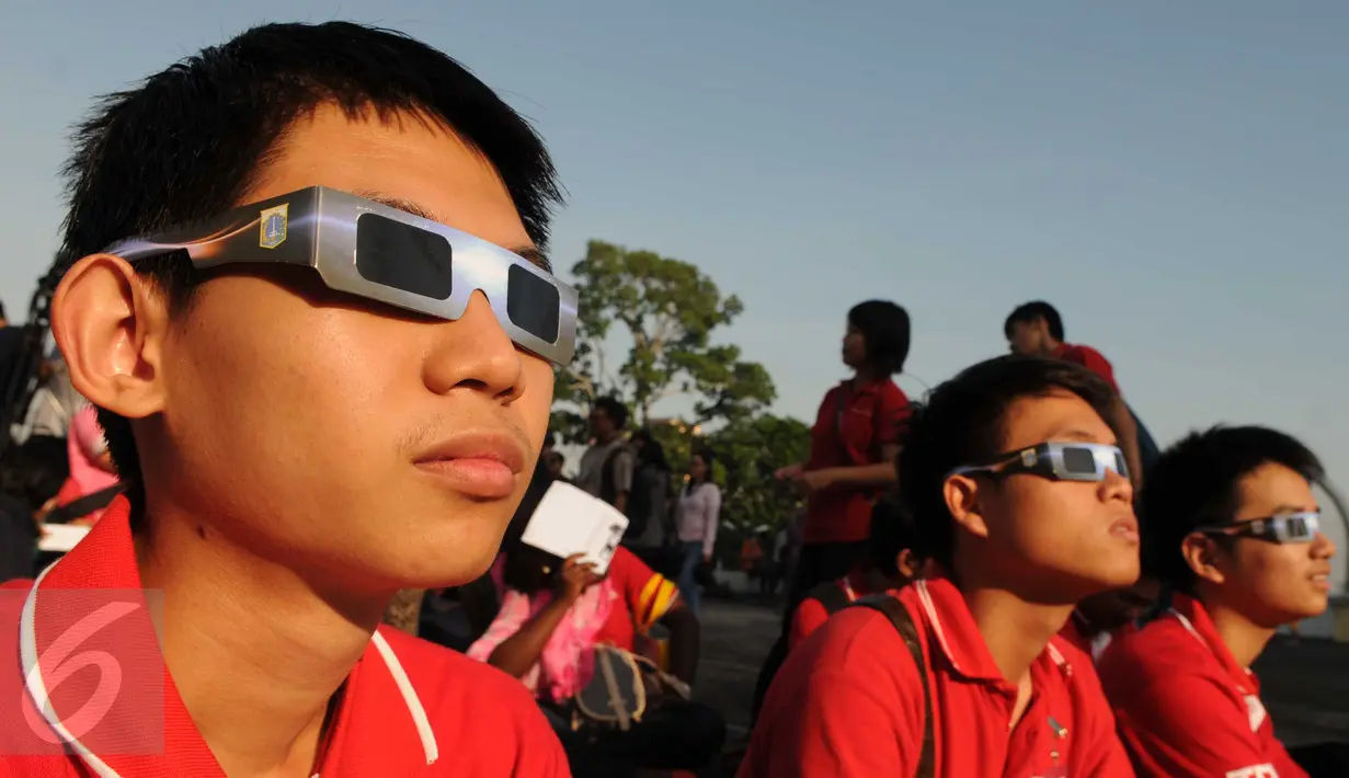 Warga menikmati fenomena Gerhana Matahari Total dengan menggunakan kacamata khusus di Planetarium, Jakarta, Rabu (9/3). Gerhana matahari di Jakarta terlihat sebagai gerhana matahari sebagian dengan ketertutupan 88,74 persen. (Liputan6.com/Helmi Afandi)