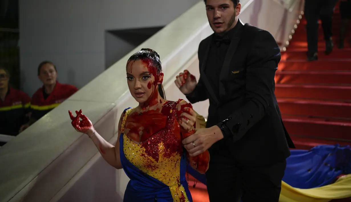 Pengunjuk rasa itu dengan cepat dibawa pergi oleh pihak keamanan di acara karpet merah. (AP Photo/Daniel Cole)