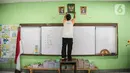 <p>Petugas merapihkan salah satu ruangan kelas di SDN Gondangdia 01, Jakarta, Senin (9/5/2022). Pemerintah memperpanjang liburan sekolah selama tiga hari yaitu 8-11 Mei 2022 di tiga provinsi yakni DKI Jakarta, Banten, dan Jawa Barat. Penambahan libur terkait upaya bersama dalam membantu mengurai kemacetan pada arus balik Lebaran 2022. (Liputan6.com/Faizal Fanani)</p>