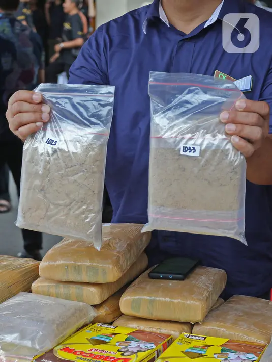 Petugas menunjukkan barang bukti dalam rilis akhir tahun di Balai Polda Metro Jaya, Jakarta, Jumat (27/12/2019). Polisi juga menampilkan barang bukti ganja dengan total mencapai 1 ton yang diamankan dari setiap polres dan wilayah hukum Polda Metro Jaya. (Liputan6.com/Herman Zakharia)