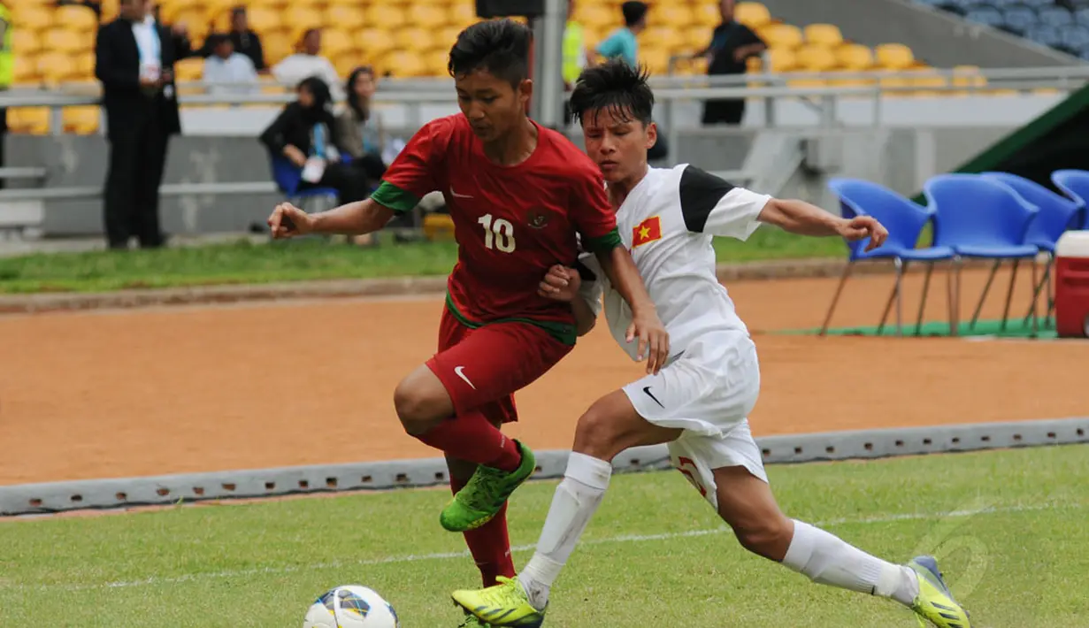 Pemain depan timnas U-16 Indonesia, Rizky Fajar (kiri) berusaha lolos dari kawalan Nguyen The Dung (Vietnam) pada laga persahabatan di Stadion GBK Jakarta, (3/12/2014). Indonesia unggul 3-2 atas Vietnam. (Liputan6.com/Helmi Fithriansyah)