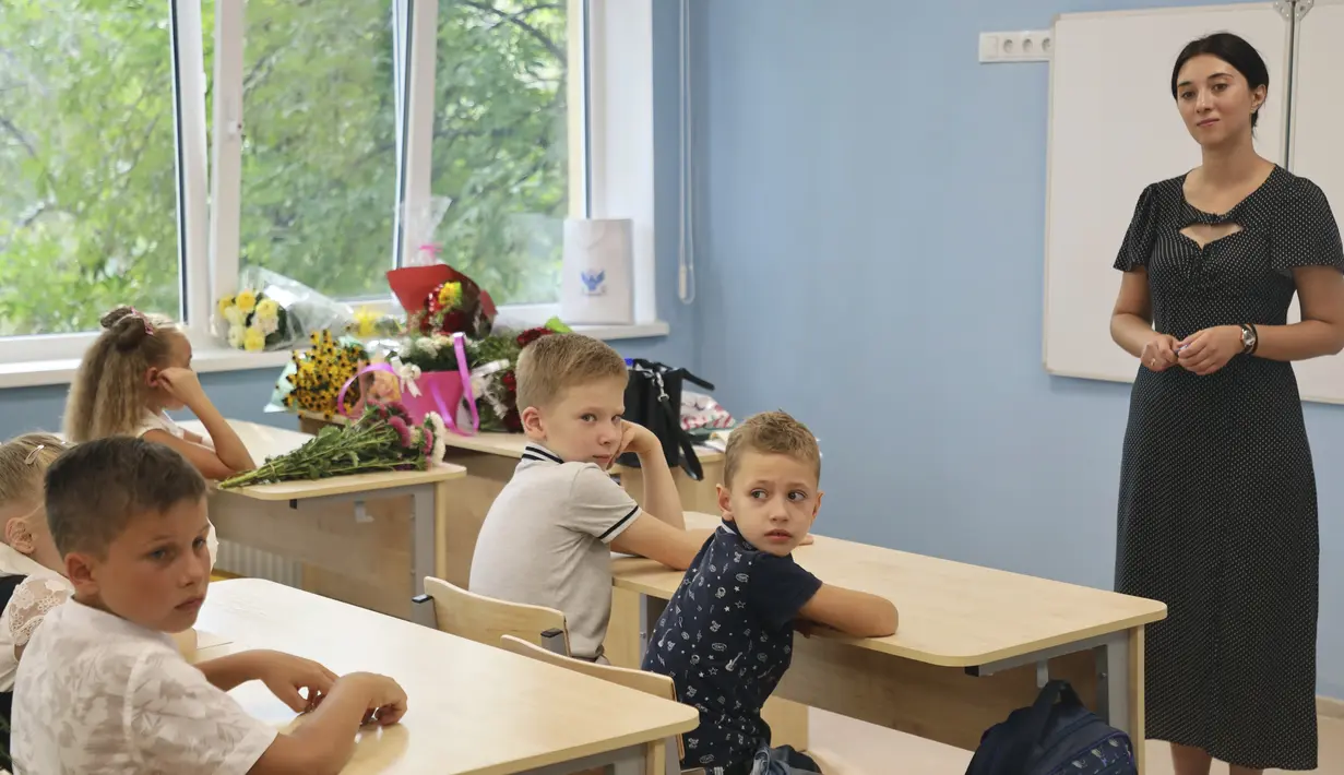 Murid-murid duduk di ruang kelas setelah upacara menandai dimulainya kelas di sebuah sekolah di Mariupol, daerah yang dikuasai oleh pasukan separatis yang didukung Rusia, Ukraina timur, Kamis (1/9/2022). Banyak sekolah Ukraina dibuka kembali pada 1 September untuk pertama kalinya sejak invasi Rusia dimulai pada 24 Februari lalu. (AP Photo)