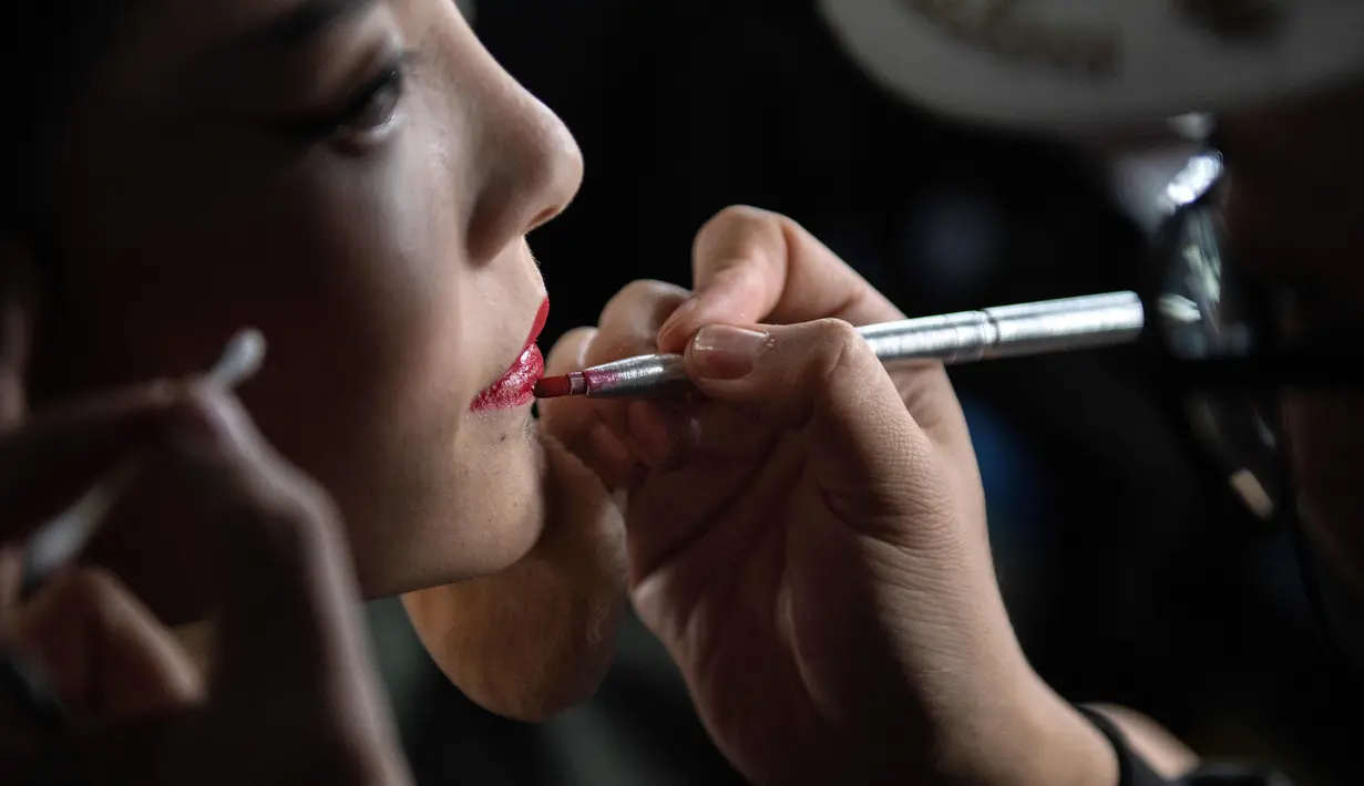 Model saat dirias di belakang panggung sebelum tampil membawakan koleksi Rabbit-Warm karya Zhuang Ganran selama China Fashion Week di Beijing (30/10). (AFP Photo/Nicolas Asfouri)