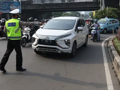 Polisi menghentikan mobil saat pemberlakuan ganjil genap di kawasan Fatmawati, Jakarta, Senin (25/10/2021). Pemberlakuan ganjil genap di DKI Jakarta diperluas menjadi 13 titik. (Liputan6.com/Herman Zakharia)