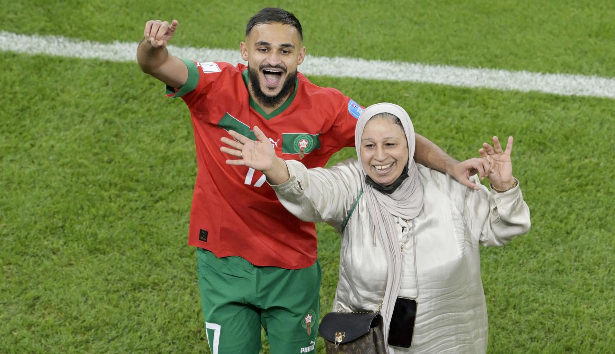 Pemain Maroko, Sofiane Boufal, merayakan kemenangan atas Portugal bersama ibunya pada laga perempat final di Stadion Al-Thumama, Sabtu (10/12/2022). (AFP/Juan Mabromata)