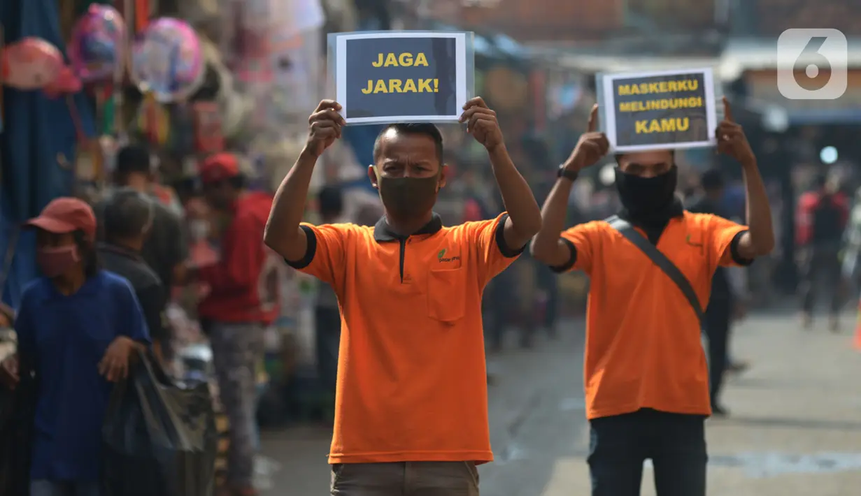 Petugas pengelola pasar melakukan kampanye dengan membawa poster kepada pedagang di Pasar Jatinegara, Jakarta, Kamis (11/6/2020). Kampanye ini merupakan bentuk kepedulian agar pasar tak menjadi tempat penyebaran corona Covid-19 (merdeka.com/Imam Buhori)