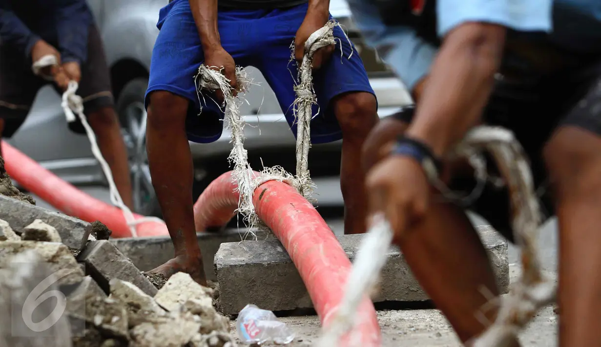 Sejumlah pekerja menarik kabel bawah tanah di Jakarta, Jumat (28/10). Mereka mengaku mendapat upah sebesar Rp.200.000 per hari. (Liputan6.com/Angga Yuniar)