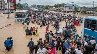 Warga melewati banjir di Distrik Ndjili, Kinshasa, Kongo pada 6 April 2025. (AFP)