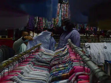 Warga memilih pakaian bekas (Thrifting) di pasar Proyek Senen, Jakarta, Selasa (12/10/2021). Akibat pandemi membuat tren thrifting menjadi alternatif pemasukan baru bagi para pedagang pakaian bekas di tengah pandemi. (merdeka.com/Imam Buhori)